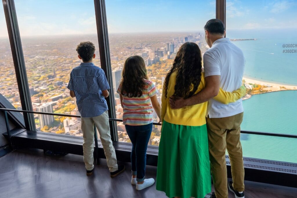 Una familia contempla Chicago y el lago Michigan desde la plataforma de observación 360 CHICAGO.